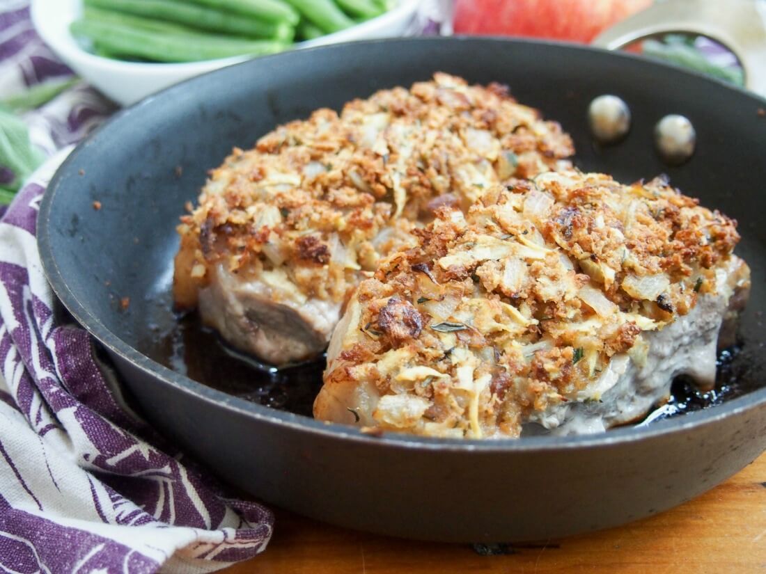 two apple stuffing crusted pork chops in skillet