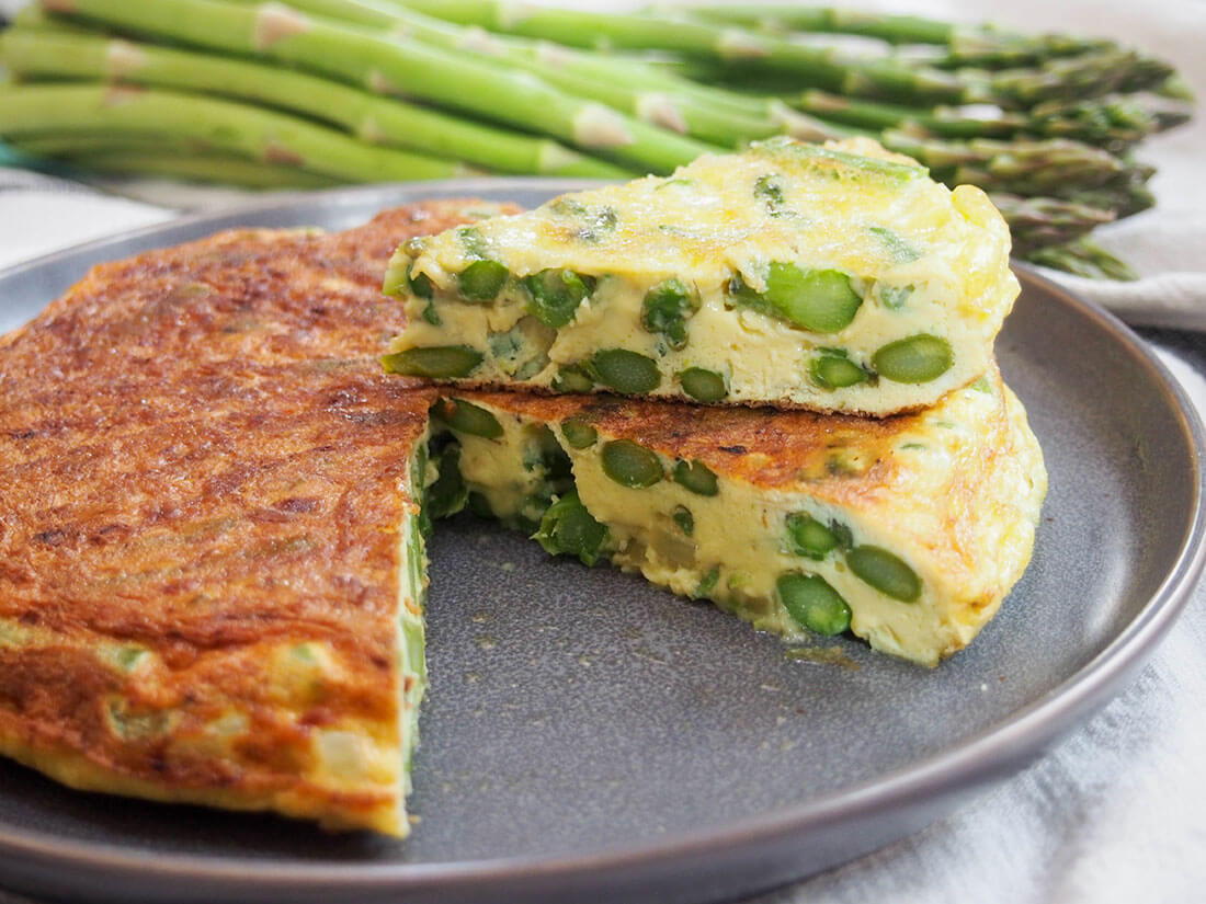 asparagus frittata with slice sitting on top of rest of frittata