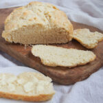 loaf of Australian damper bread with slices in front