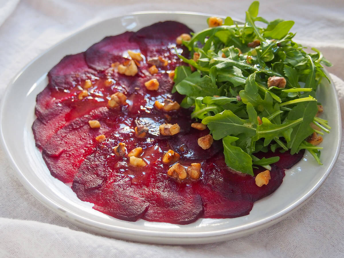 plate of beet carpaccio with arugula to side of plate