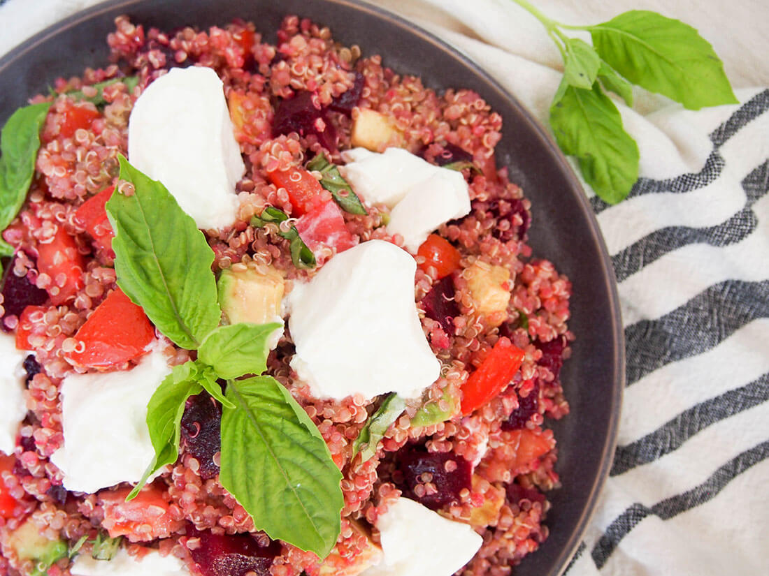 overhead view of part of plate of Caprese quinoa salad with beets and avocado