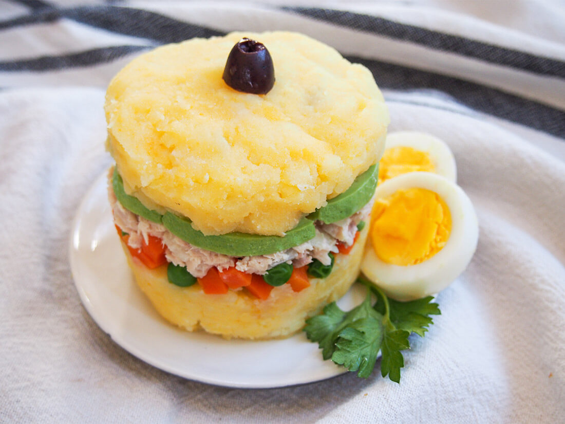 Causa rellena on plate with egg garnish