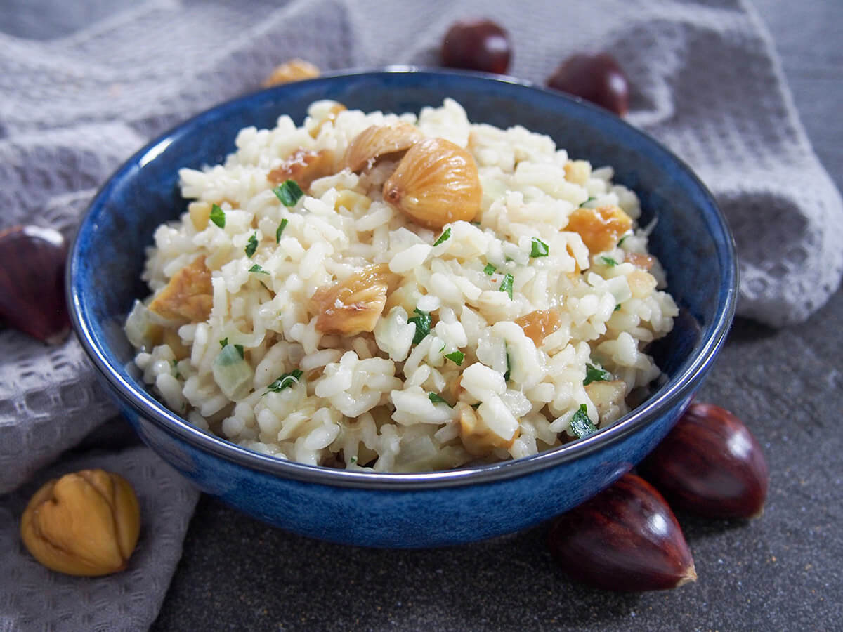 side view of bowl of chestnut risotto with whole chestnuts to side