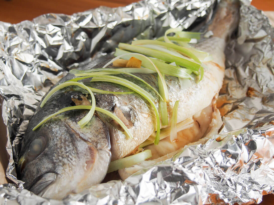 Chinese oven steamed fish in foil with head to front