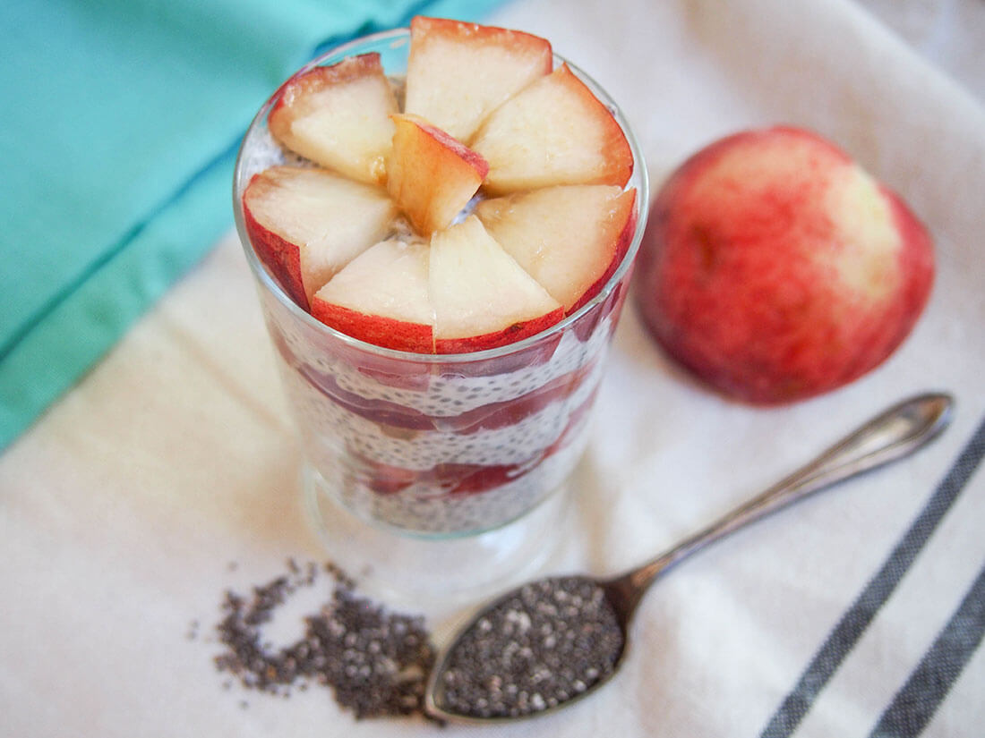 coconut chia pudding with white peach with peach to side of glass