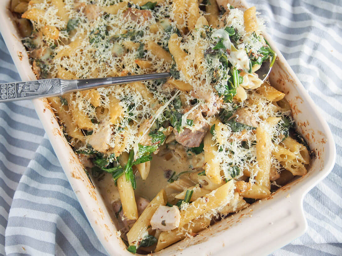 Creamy lemon chicken pasta bake in dish with spoon of pasta resting on top