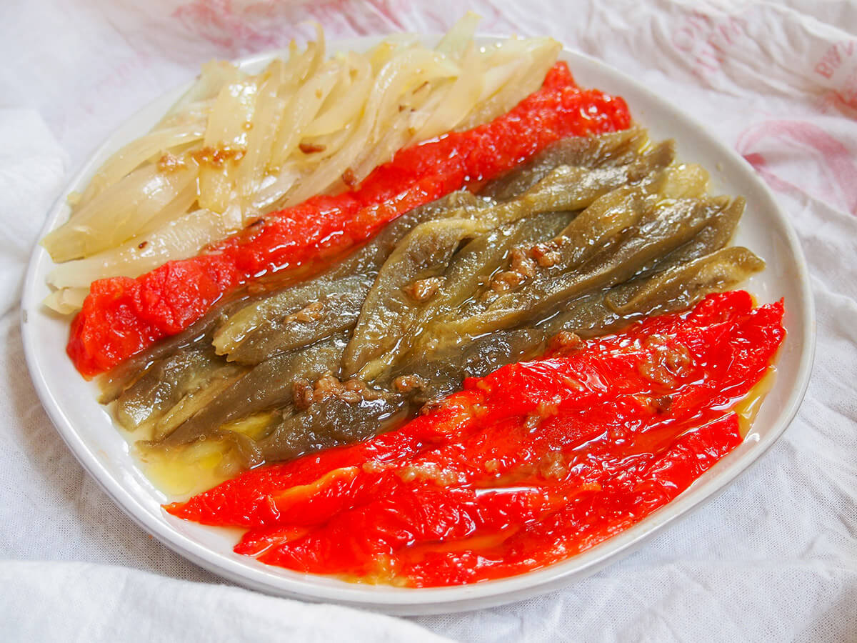 plate of escalivada Catalan roast vegetables with red peppers at front