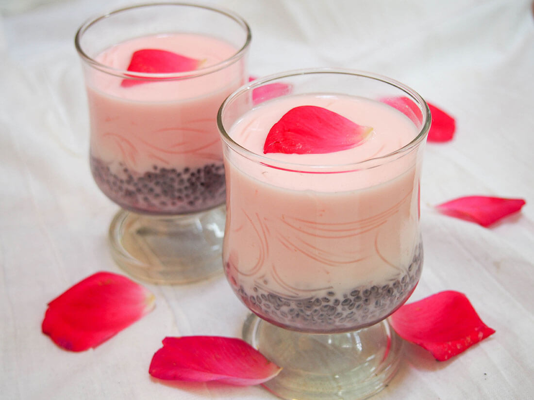 two glasses of falooda decorated with rose petals