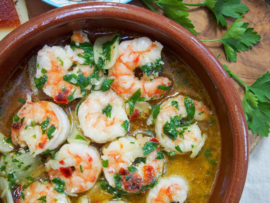 partial view of dish with gambas al ajillo (Spanish garlic shrimp)