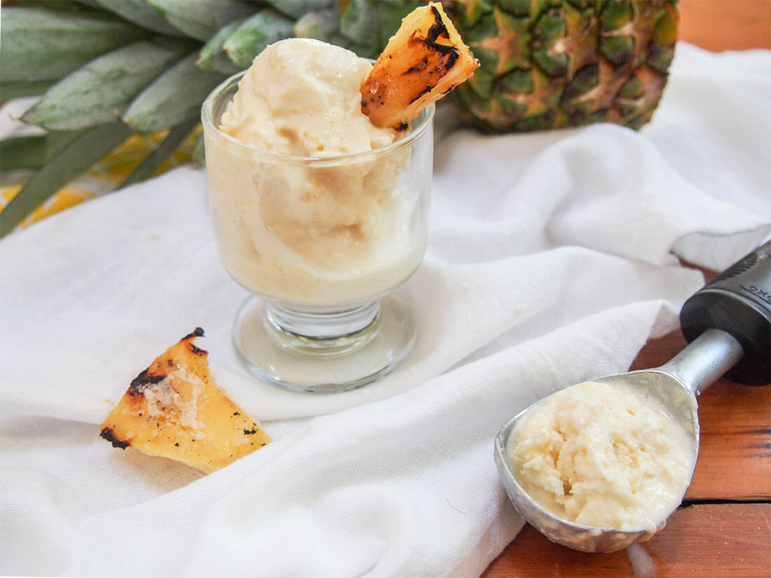 grilled pineapple ice cream in glass with scoop to side