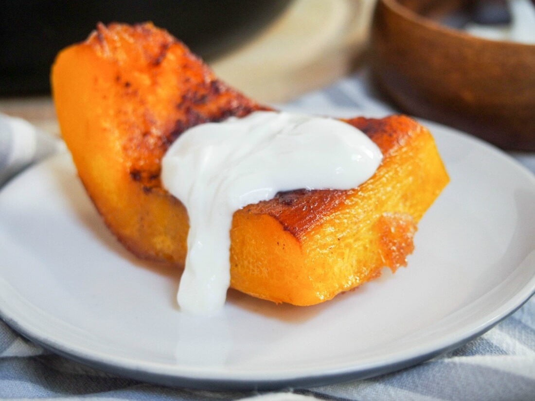 piece of Kaddo bowrani, Afghan pumpkin, topped with yoghurt sauce