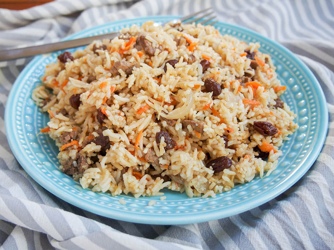 plate of lamb pilaf with fork at back of plate