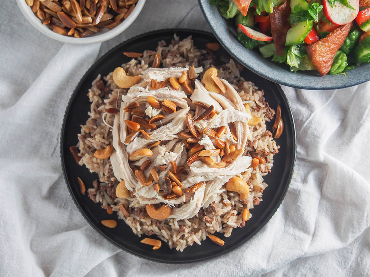 plate of Lebanese chicken and rice from overhead with bowl of salad above