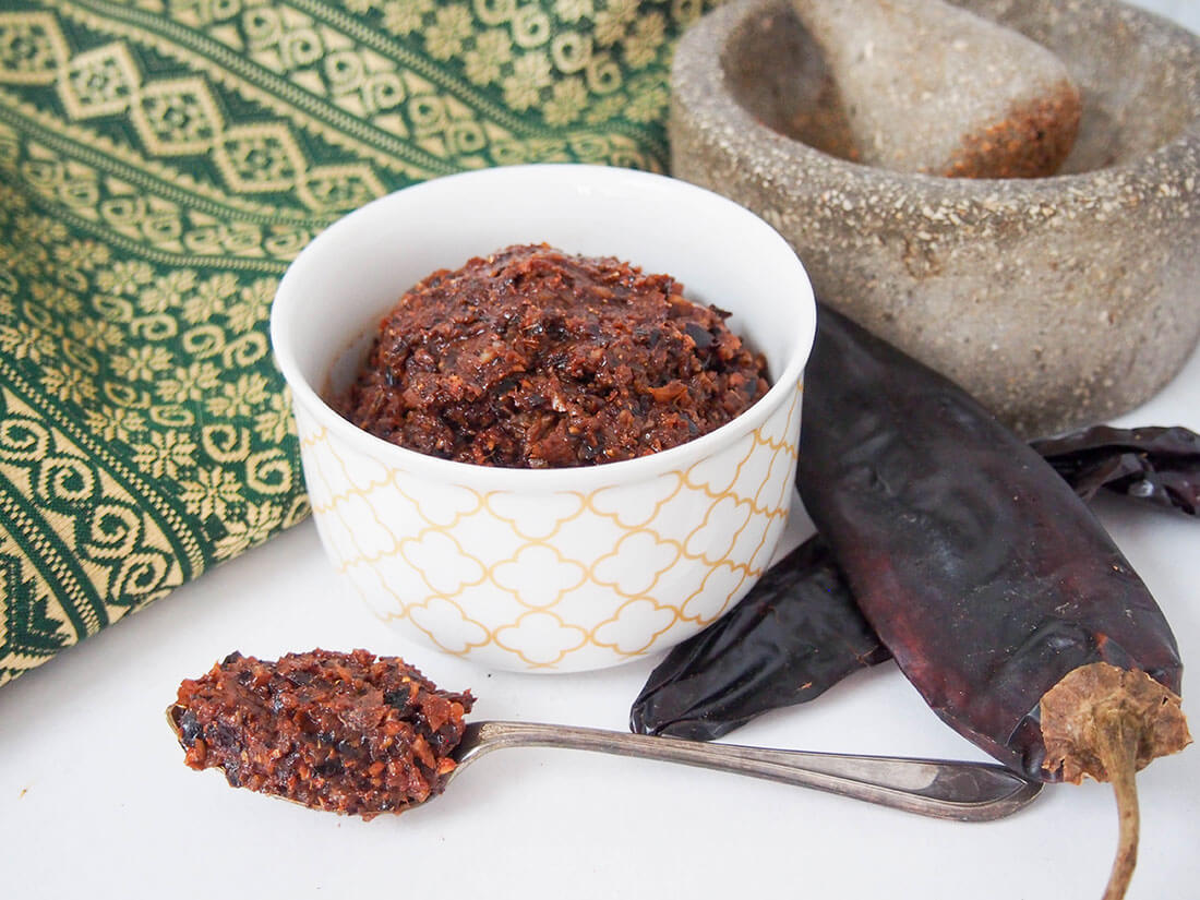 massaman curry paste with chilis and pestle and mortar to side