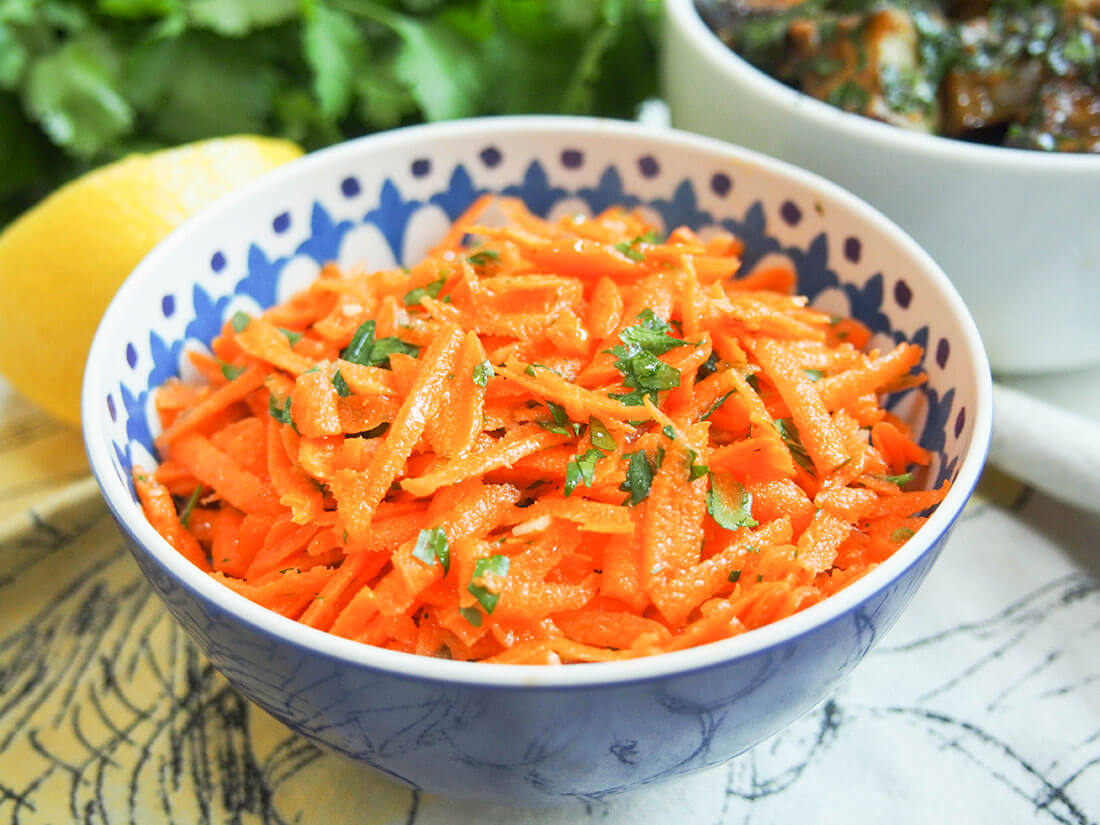 Moroccan raw carrot salad with eggplant salad, lemon and cilantro behind