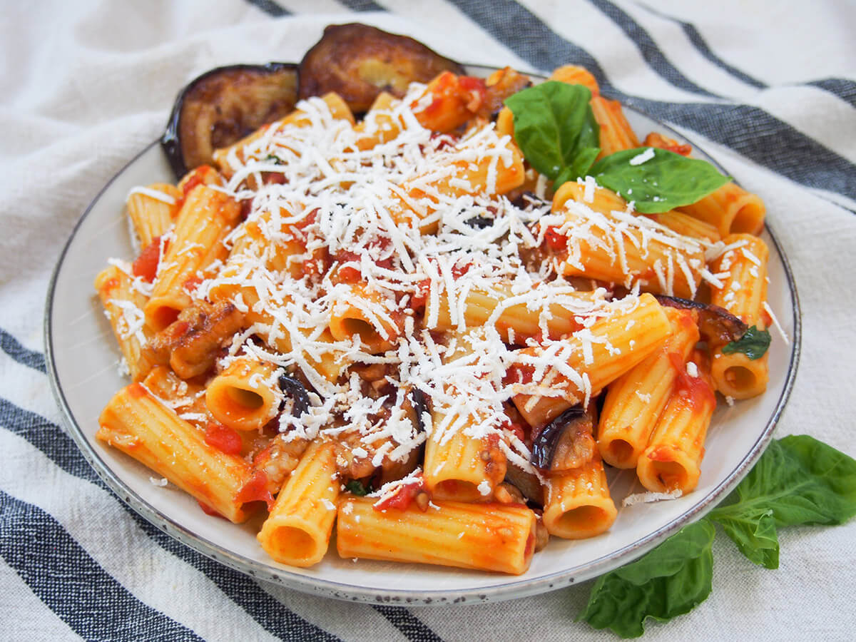 plate of pasta alla Norma with basil leaf garnish