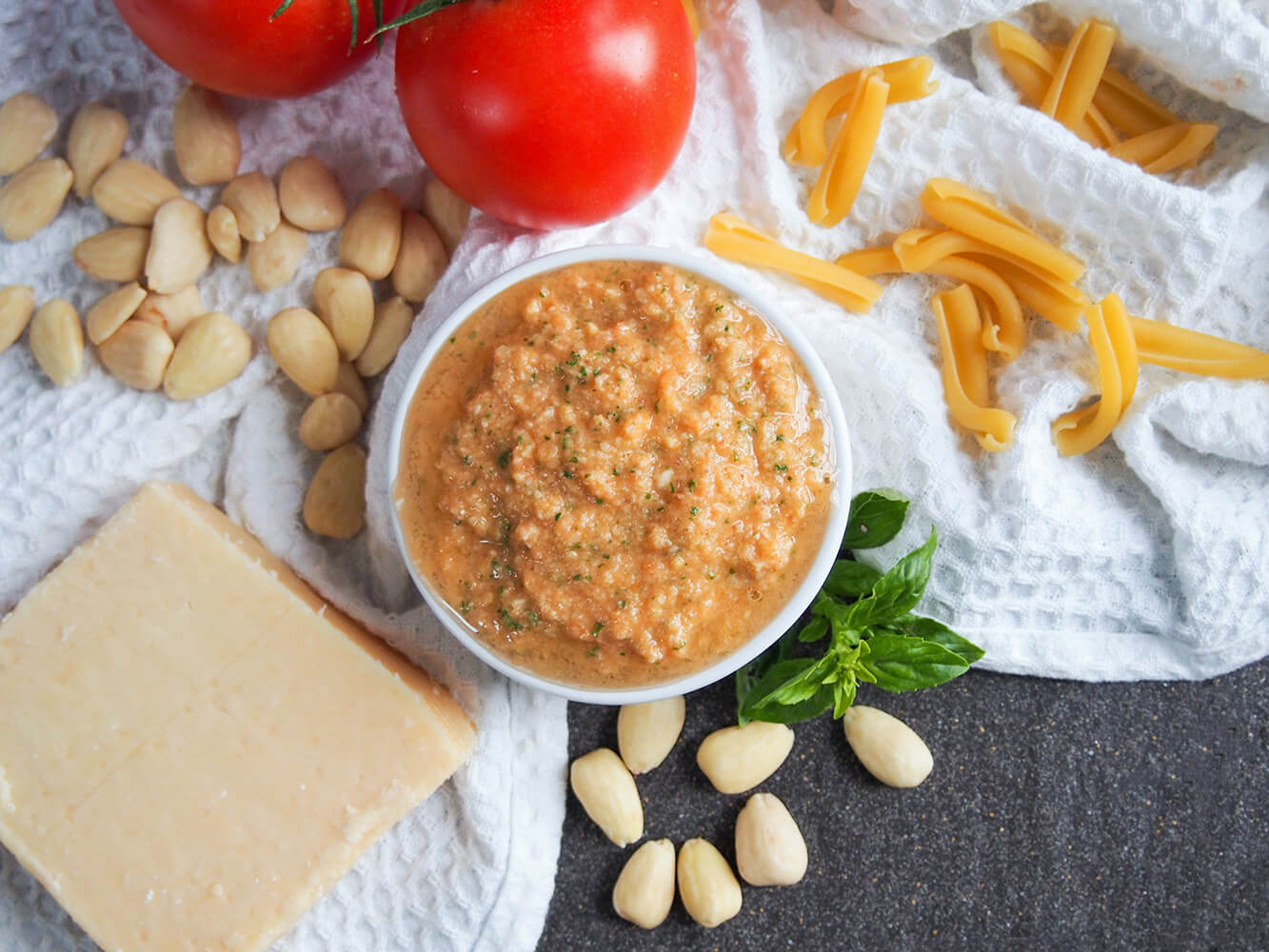 Pesto alla Trapanese in dish from overhead with ingredients around it