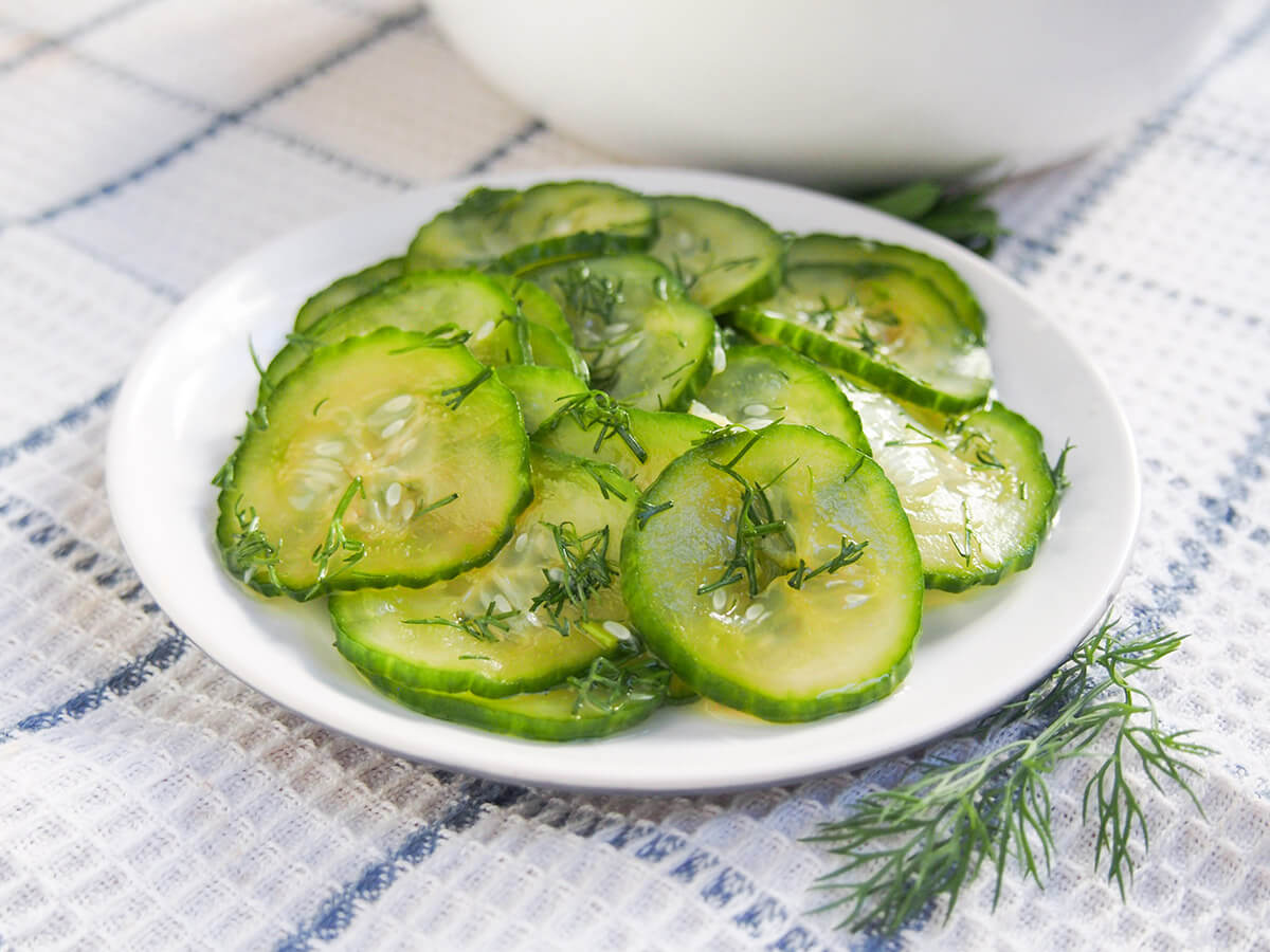 plate of pressgurka Swedish cucumber with sprig of dill to side