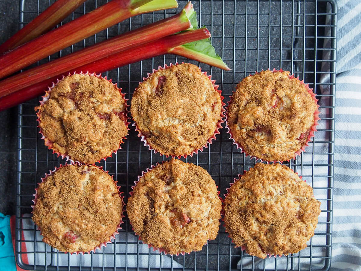 rhubarb muffins on cooling rack with rhubarb above