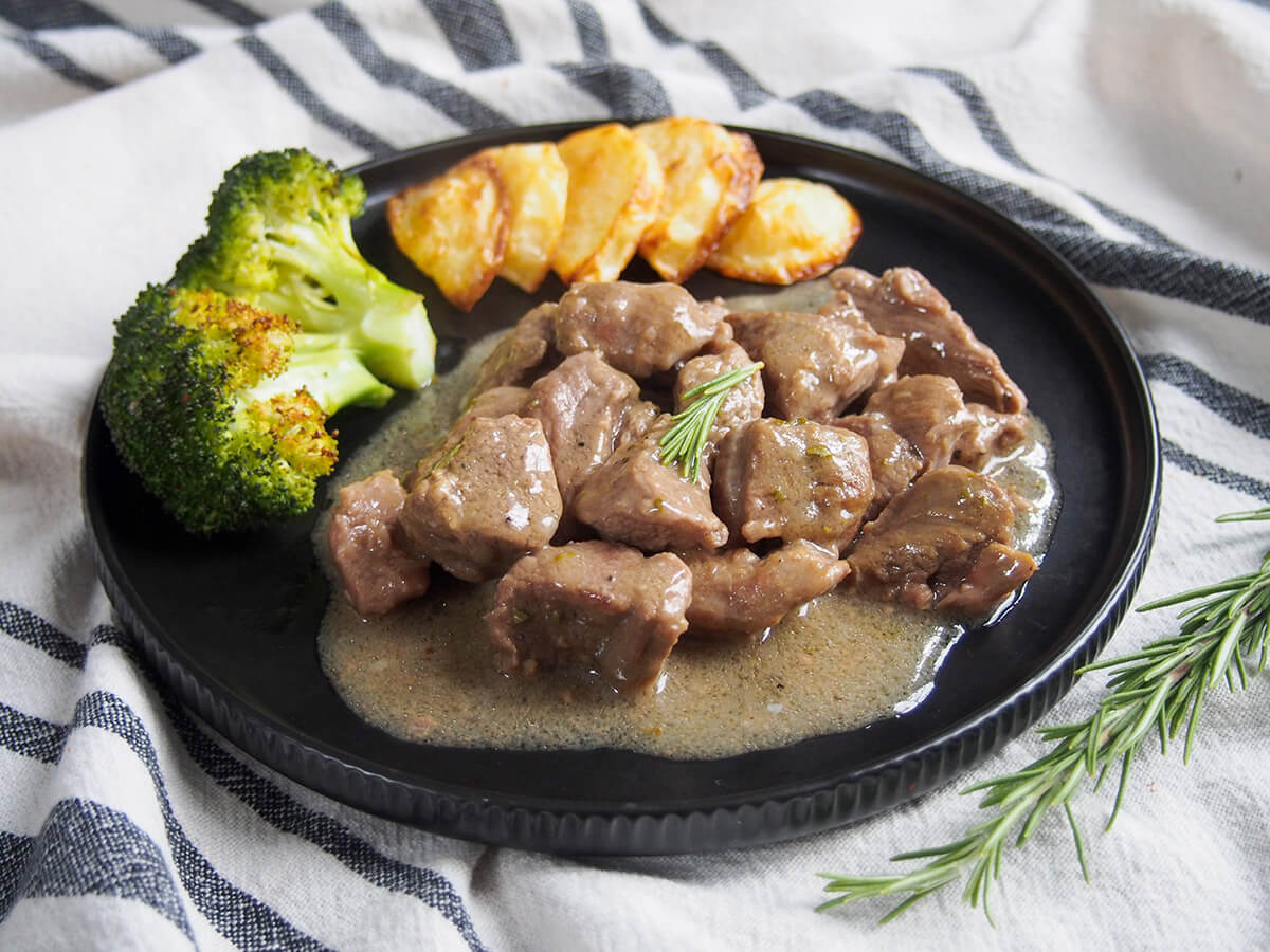 plate of Roman lamb stew, abbacchio alla cacciatora, with broccoli and potatoes