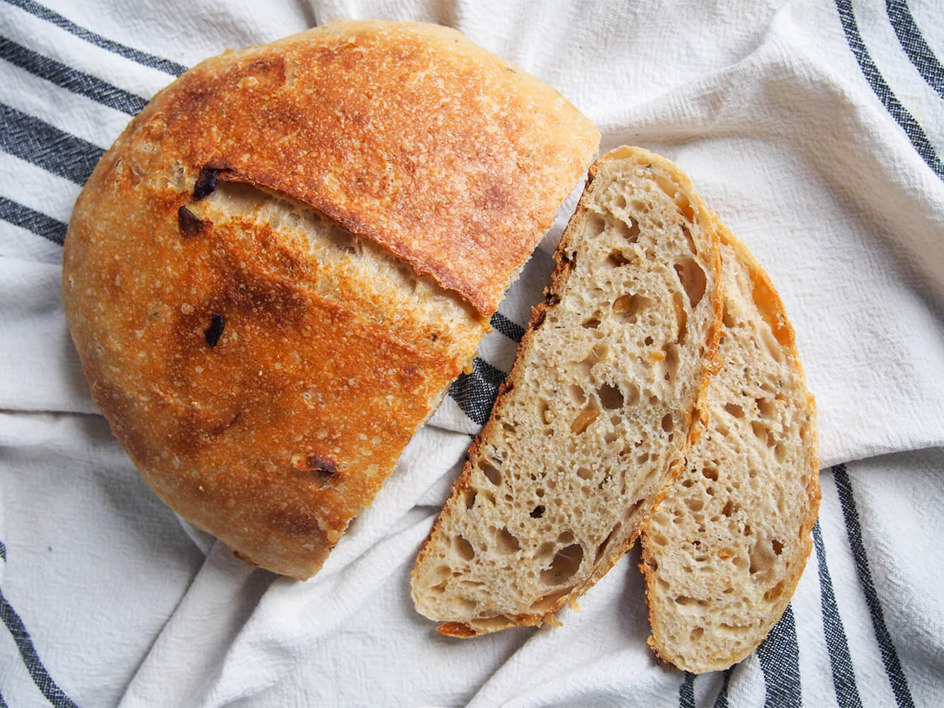 sage and caramelized onion sourdough bread from overhead with two slices to side