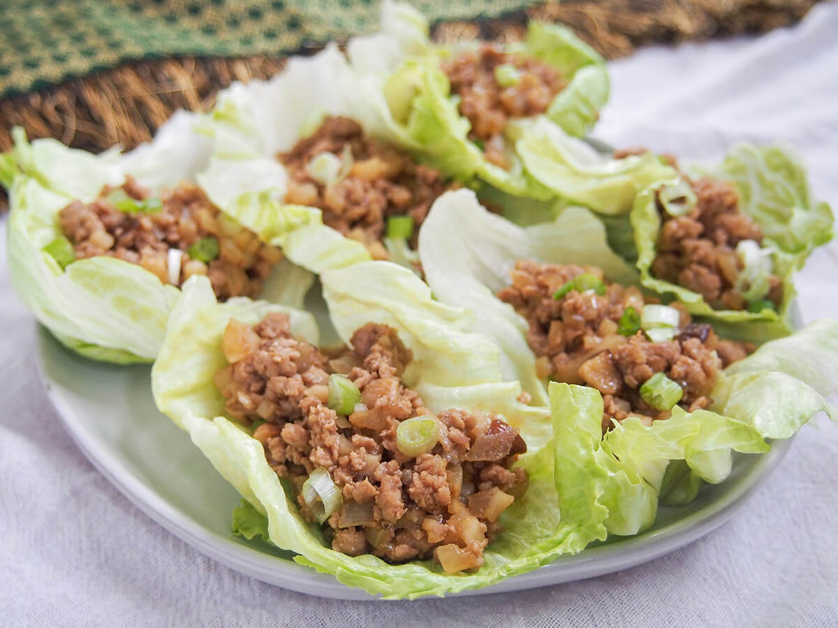 plate of san choy bow Chinese lettuce cups with cloth behind plate