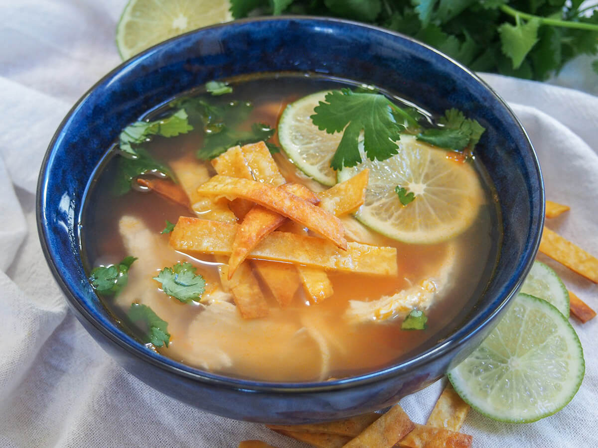 bowl of sopa de lima topped with tortilla strips