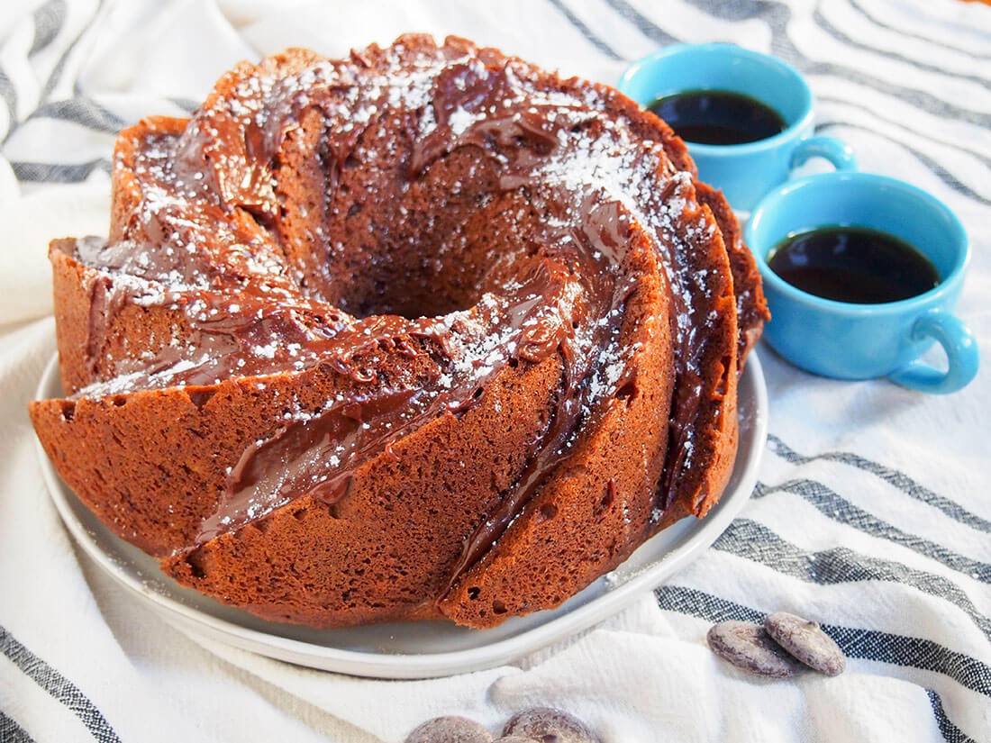 whole sour cream mocha cake with two cups of coffee to side