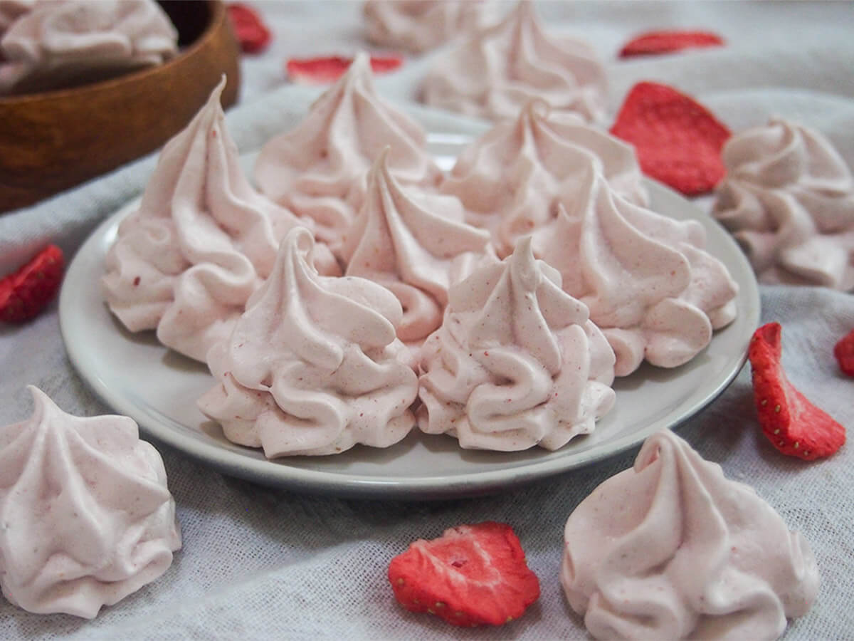 plate of strawberry meringue cookies with dried strawberries around plate