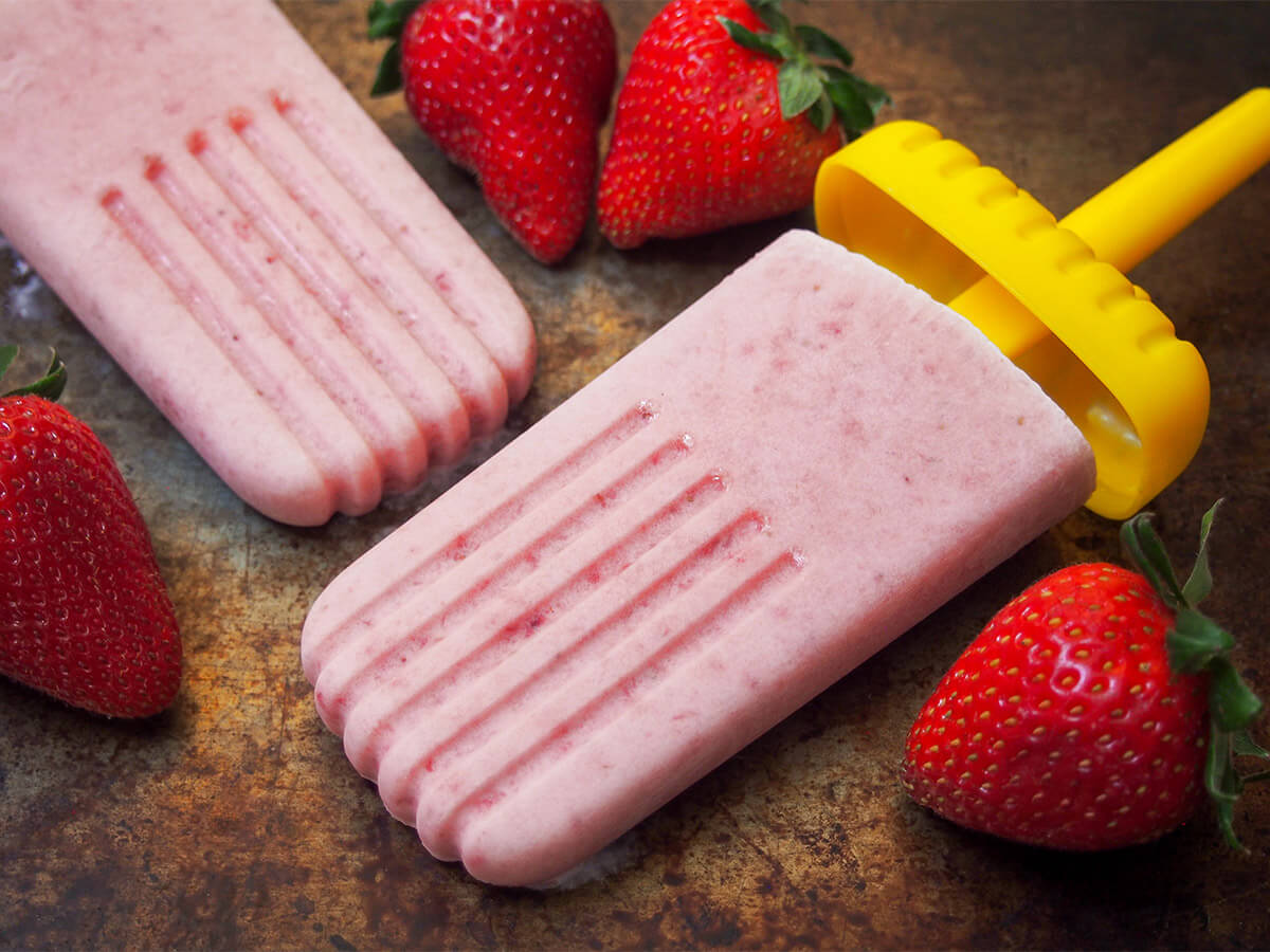 strawberry paletas with strawberries around them