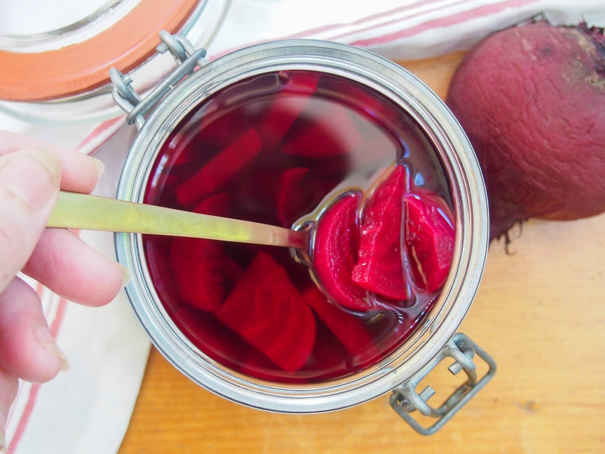 overhead view of jar of pickled beets with a few slices lifted on fork