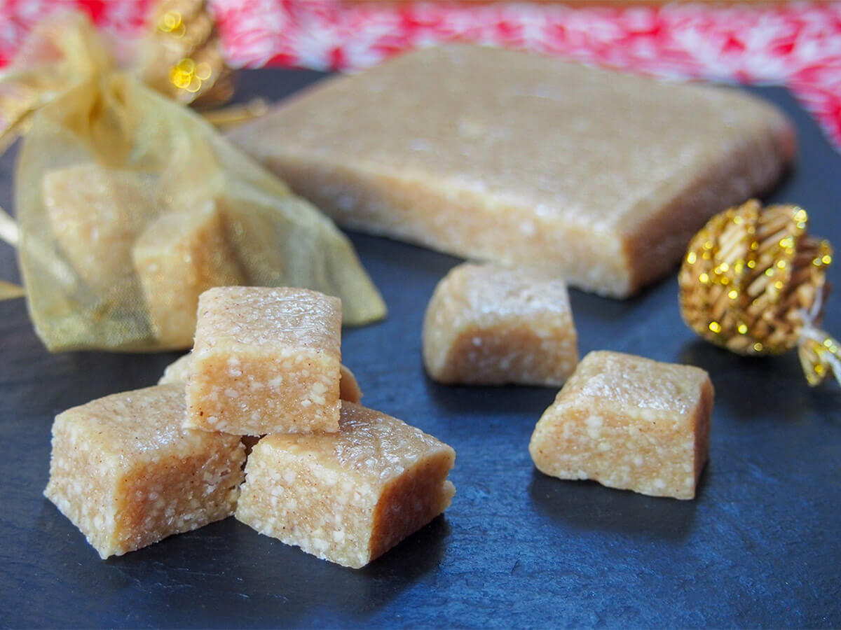 small stach of cubes of turron de Jijona with more to side and block behind