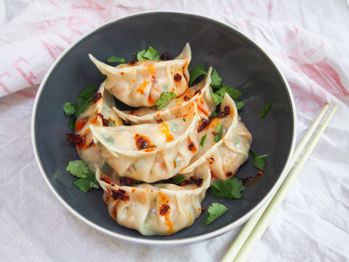 bowl of vegetable dumplings (jiaozi) with chopsticks to side