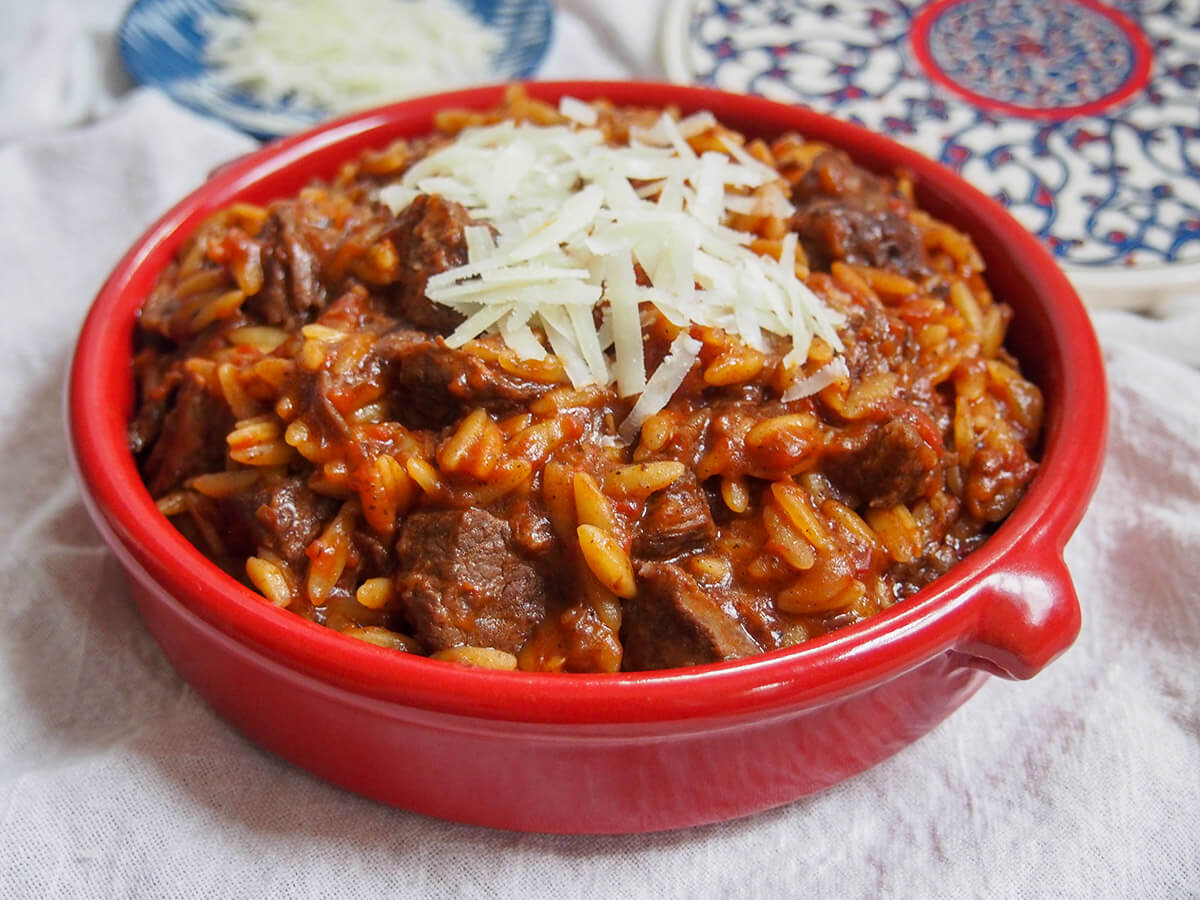 terracotta dish filled with youvetsi and topped with a little cheese