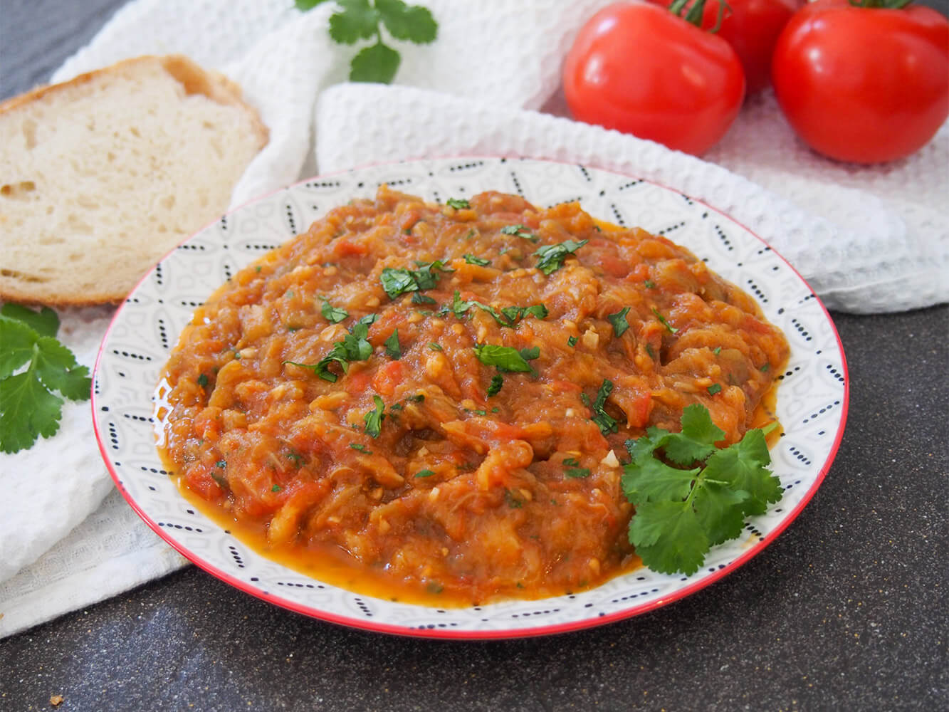 Zaalouk (Moroccan eggplant salad) on plate with bread to side